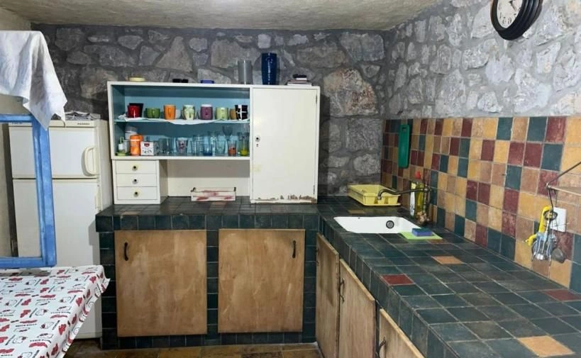 Casa de pedra à beira-mar com um terraço coberto