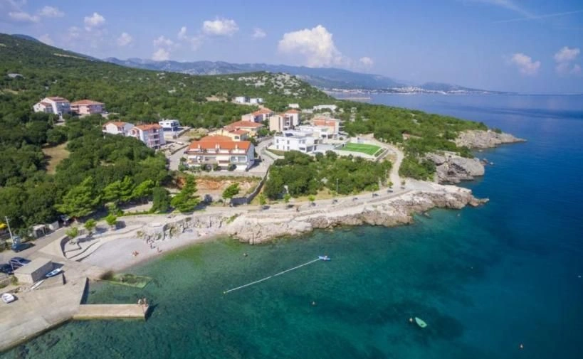 Casa de pedra à beira-mar com um terraço coberto